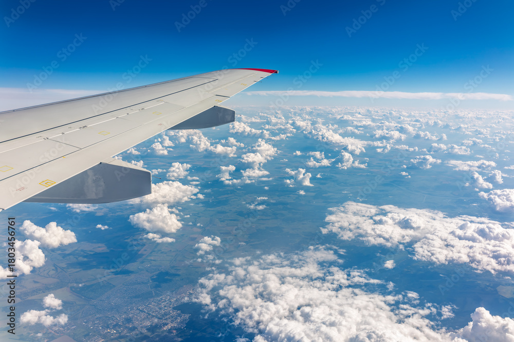 Obraz premium View from the airplane window at a beautiful cloudy sky and the airplane wing