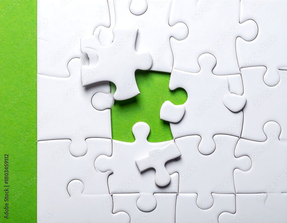 Fototapeta premium White jigsaw puzzle with green backing; one piece is missing