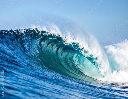 Fototapeta Naklejka Na Ścianę i Meble -  A vibrant ocean wave curves, revealing turquoise light within its crest, contrasted against a clear blue sky