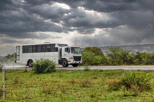 Remote Access Vehicle RAV converted bus body , on an open road in the heavy rain storm, transporting people personnel .