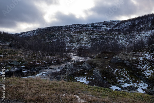 Swamp with small pine trees covered in early winter morning frost reflecting in pond. national park at sunrise with fog rising, scandinavia