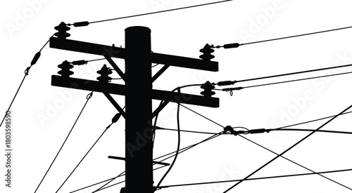 Utility pole silhouette with multiple overhead electrical wires and insulators creating complex power line connection network