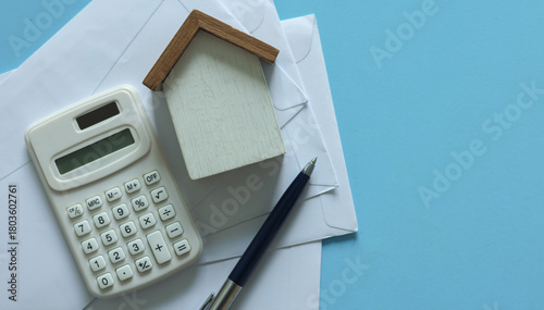 close up top view group of home model ,pen, calculator and invoice letter on blue color background with space for money management ,home loan and personal financial concept