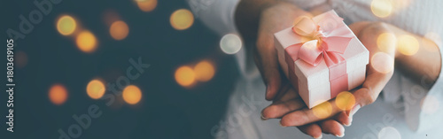 Females holding Christmas gift box decorated with Christmas and New Year banner Concept merry christmas and happy new year 2025 , 2026