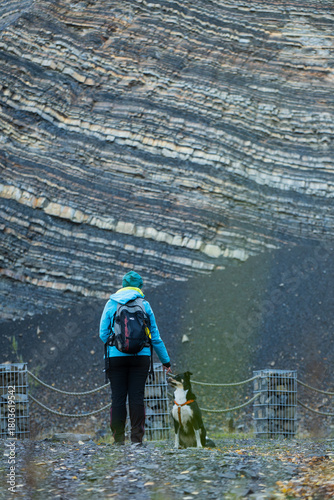 Fototapeta Naklejka Na Ścianę i Meble -  Turystka z psem na tle ściany skalnej w kamieniołomie w Kozach. 