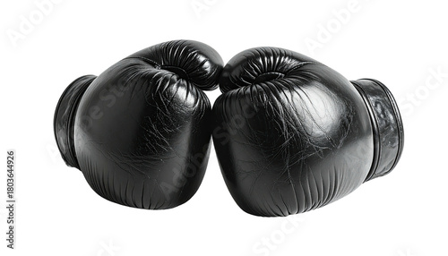 Two black boxing gloves facing each other against black backdrop