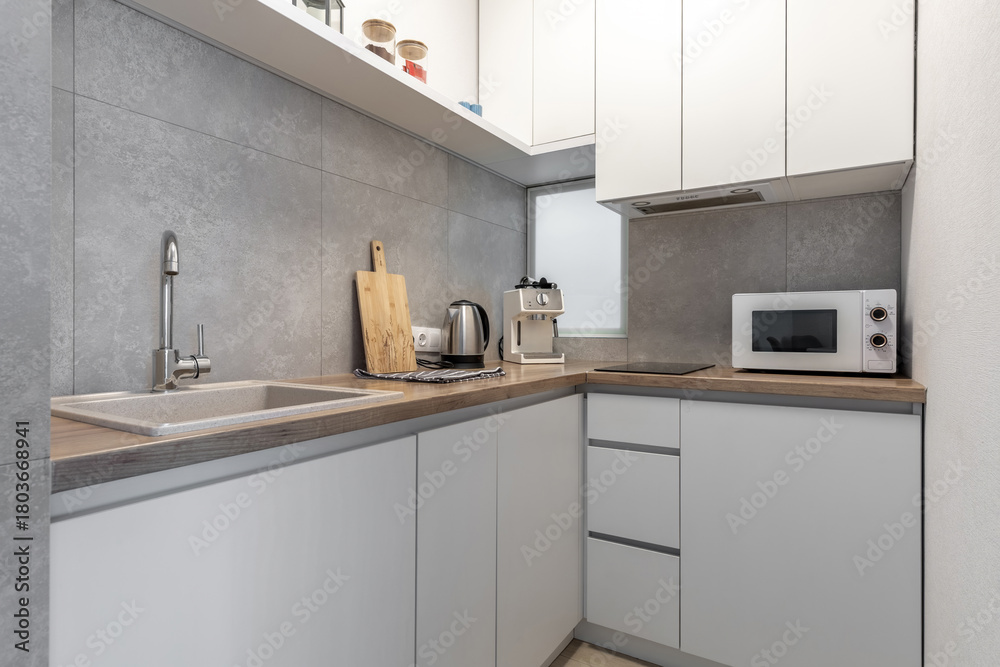 Fototapeta premium Modern Compact Kitchen with Wooden Countertop and Appliances