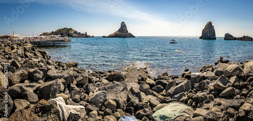 Fototapeta Naklejka Na Ścianę i Meble -  Islands of the Cyclops, off the coast of Aci Trezza, Sicily. These tall, prominent sea stacks, were, according to local legend, the great stones thrown at Odysseus in the epic poem The Odyssey.