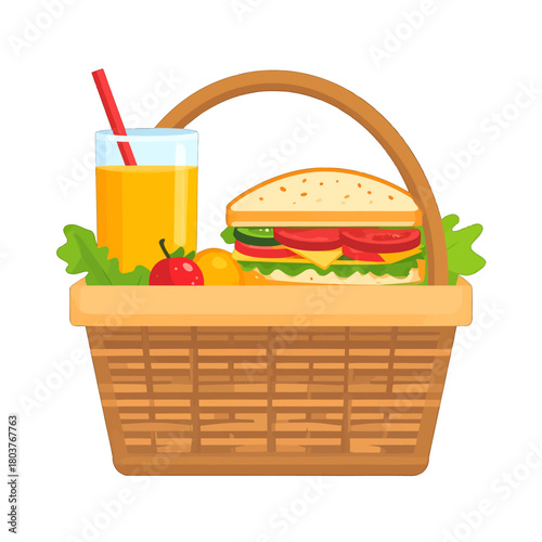 Wicker picnic basket filled with a tall sandwich juice and fresh fruit on a sunny day