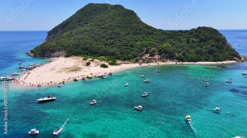 Aerial drone cinematic video of scenic caves and turquoise beach in paradise island of Marathonisi in bay of Laganas, visited by small boats a true tourist attraction, Zakithnos island, Ionian, Greece