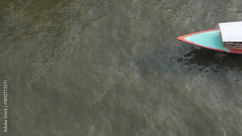 Aerial view of a passenger boat sailing on the Saen Saep Canal to pick up and drop off passengers at piers in Bangkok.Traveling by ferry is another option that can avoid traffic congestion on the road