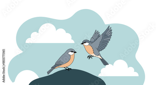 Two small birds perched on a dark rock with one flying into the soft blue sky.