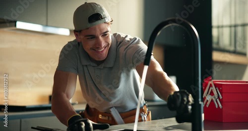 Man, plumber and wrench at kitchen sink with faucet installation, smile and water flow with renovation at house. Person, tap and plumbing tools with solution, happy and property development in home
