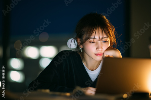 Young woman working late on laptop at night