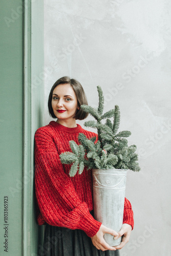 Woman Holding Christmas Tree in Pot