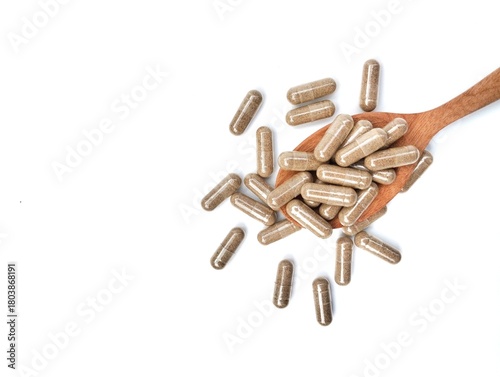 Herbal capsules on wooden spoon isolated on white background. Organic supplements for health, Flat lay 