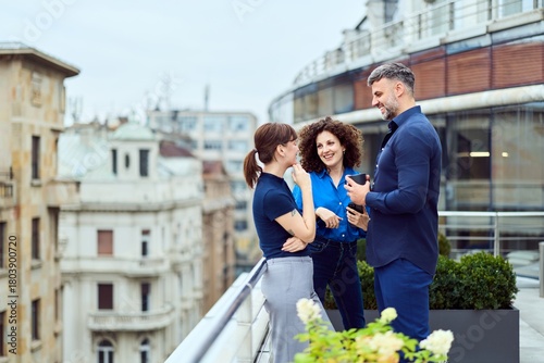 Professional Friends On Rooftop Terrace Discussing Business In City Skyline