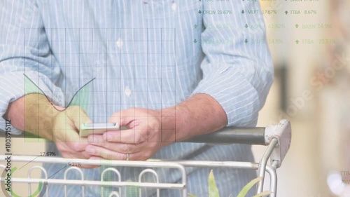 Senior shopper tapping phone checking list in grocery showing charts, placing phone, pushing cart