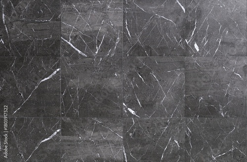 Large gray square granite tiles with white streaks. Background and texture. Full frame.