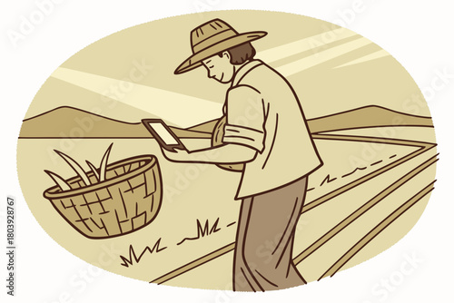 Farmer in straw hat using tablet in agricultural field