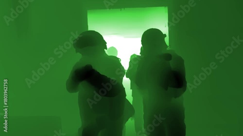 Group of armed soldiers moving through a dark hallway under night vision, silhouettes outlined by bright backlight, conveying tactical movement and military operation.