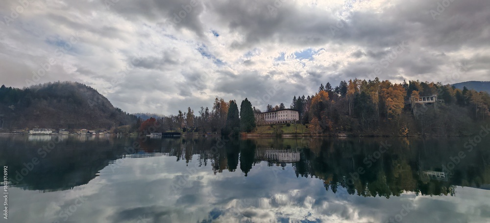 Fototapeta premium Bled - Slovenia - Mountain lake with reflective water and dramatic cloudy sky