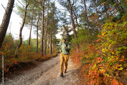 Happy runner on the forest path in autumn