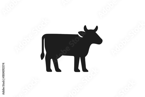 Black silhouette of a standing cow or cattle isolated on a white background