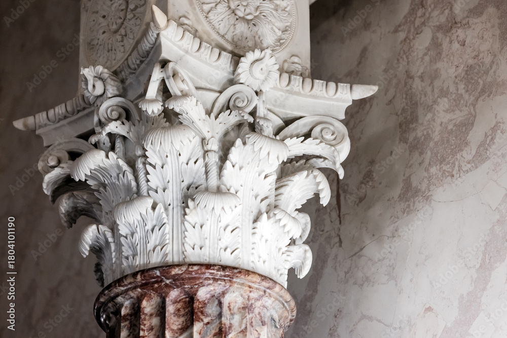Fototapeta premium A finely detailed Corinthian capital with acanthus leaves and scroll work