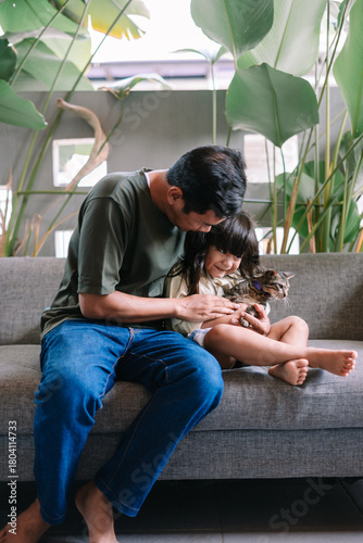 Joyful girl and man bonding with their cute feline friend