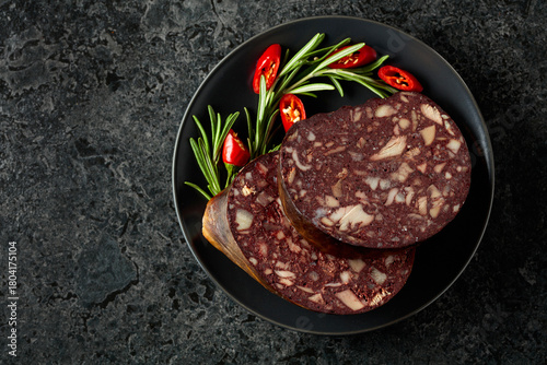 Photography Spanish black pudding or blood sausage accompanied by rosemary and red pepper