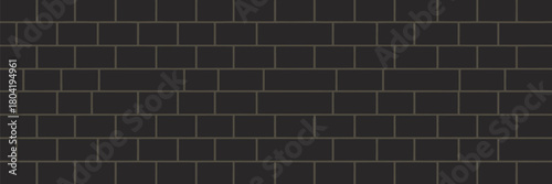 A dark gray brick wall with a running bond pattern and gray grout creating a uniform textured surface look