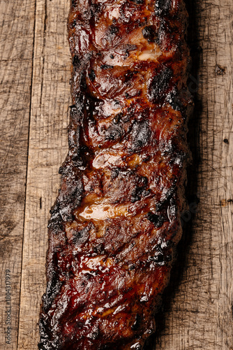 Close-up of heavily charred barbecue ribs with glossy glaze and burned textures, symbolizing extreme heat and fire aftermath, dramatic food abstraction with rustic details.
