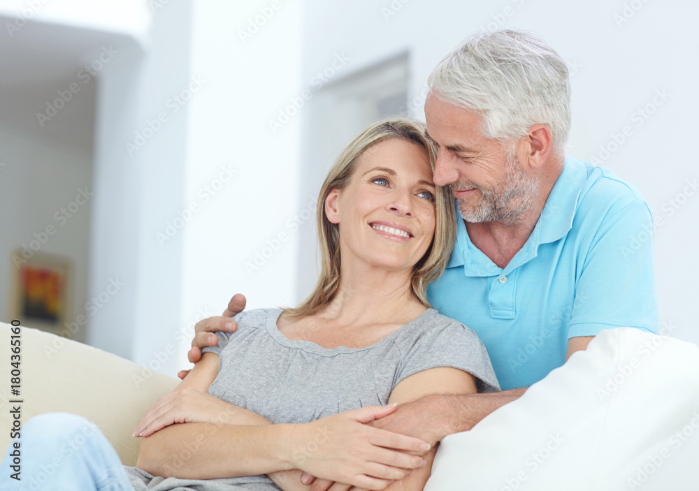 Obraz premium Mature couple, relax and hug on sofa with love, bonding or healthy relationship in home. Man, woman and embrace in living room with commitment, support and together in marriage for weekend break