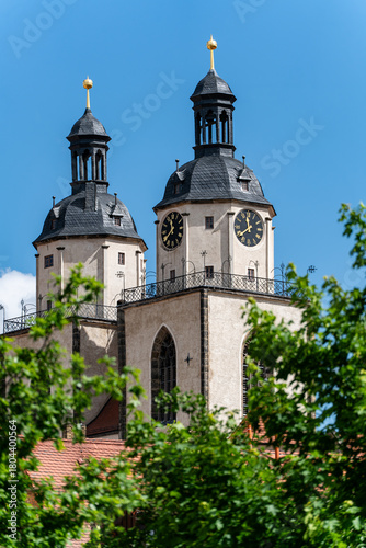Towers of St. Mary’s Church in Wittenberg peeking out from behind trees. Historic Reformation church linked to Martin Luther.