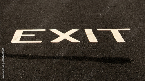 Exit sign painted on asphalt in a parking lot