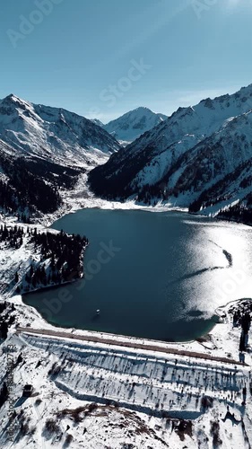 Aerial view of mountain lake at winter with snow