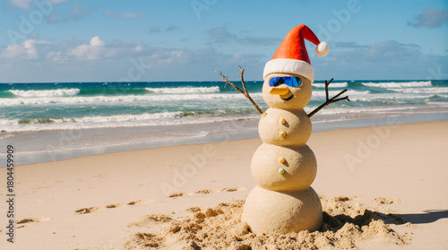 Sand snowman wearing santa hat and sunglasses on a tropical beach