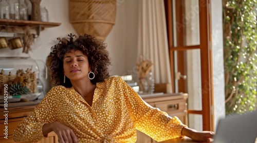 Relaxed Woman Stretching and Enjoying a Peaceful Moment at Home, Young Woman Taking a Wellness Break in a Cozy Sunlit Workspace, Casual Self-Care Moment with Natural Light and Indoor Plant