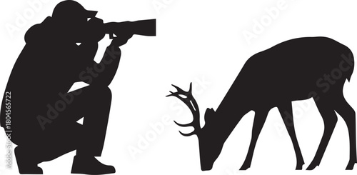 Silhouette of photographer crouching capturing image of deer grazing in nature