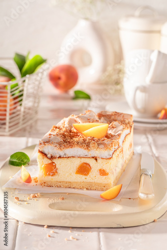 Tasty peach cheesecake served in the kitchen on the counter.