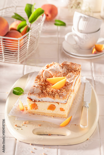 Sweet peach cheesecake served in the kitchen on the counter.