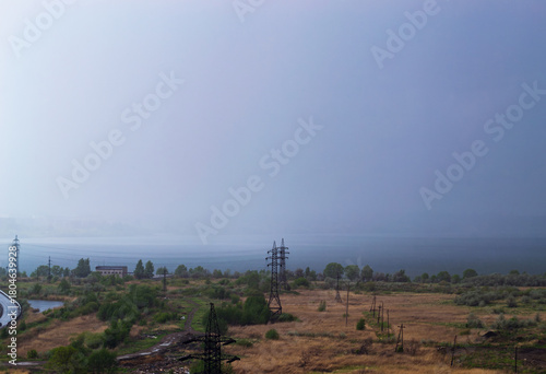 Rainstorm over lake and industrial cityscape