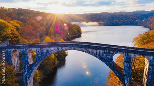 Wallpaper Mural Stone arch bridge over a river surrounded by autumn foliage with sun rays in the background Keywords: bridge, arch bridge, stone bridge, river, water, autumn Torontodigital.ca