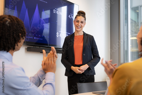 Team Applauds young employee at Successful Business Presentation