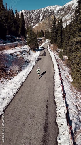 Man running at the road in the mountains