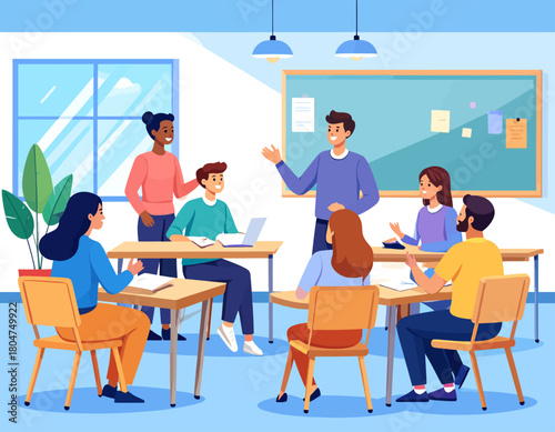 A teacher leads a classroom discussion with students seated at desks, some using laptops and notebooks, in a bright, modern classroom setting.