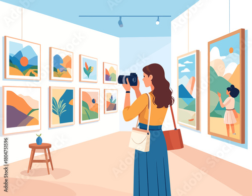 Woman with long brown hair photographing artwork in a bright and modern art gallery, surrounded by colorful abstract paintings.