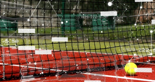 Sitting yellow tennis ball resting near net on red hard court, HUD overlay, copy space