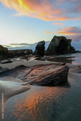 Wall Mural Rocas en una playa iluminadas por los últimos rayos del sol en un atardecer del otoño